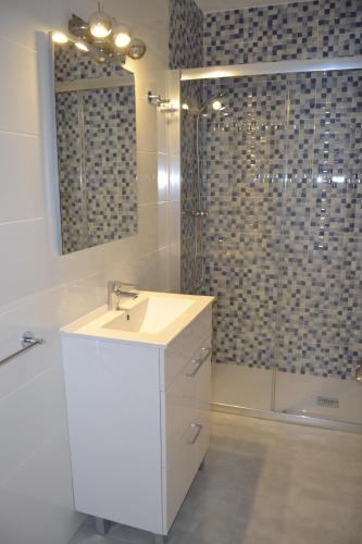 ein weißes Bad mit einem Waschbecken und einer Dusche in der Unterkunft PRECIOSO APARTATAMENTO JUNTO AL MAR in Peñíscola