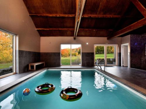 Modern Villa in Durbuy with Swimming Pool في Villers-Sainte-Gertrude: مسبح في بيت فيه شباك كبير