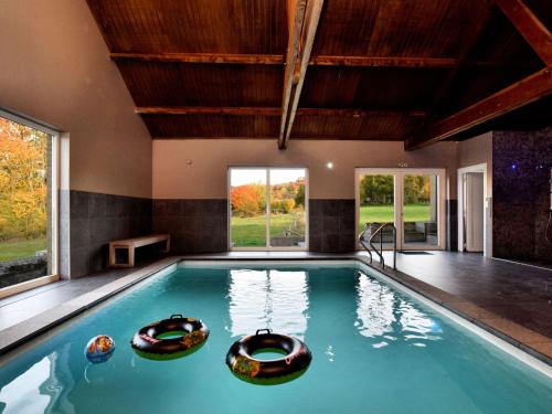 Villers-Sainte-GertrudeにあるModern Villa in Durbuy with Swimming Poolの大きな窓のある家の中のスイミングプール