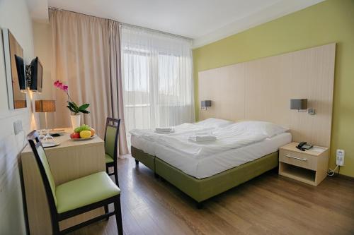 1 dormitorio con 1 cama, 1 mesa y 1 silla en Ensana Spa Smrdáky, en Smrdáky