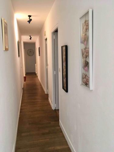 a hallway with paintings on the walls of a room at La grande maison de Carrouges in Carrouges