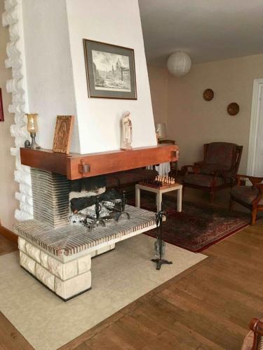 a living room with a fireplace with a piano at La grande maison de Carrouges in Carrouges