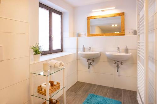 a bathroom with two sinks and a mirror at Ferienwohnungen Karwendelbahn in Mittenwald