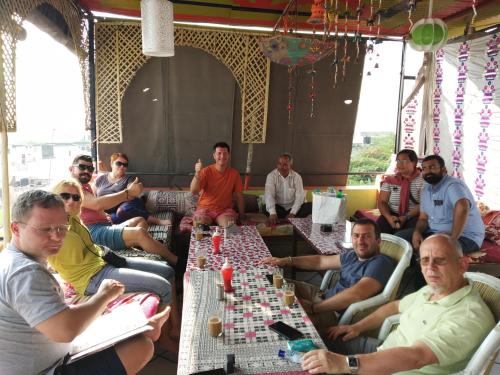 a group of people sitting around a table playing chess at Hotel Paramount Palace in Pushkar