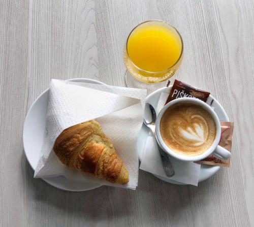 a cup of coffee and a pastry and a cup of orange juice at Apartmaji Janković in Logatec