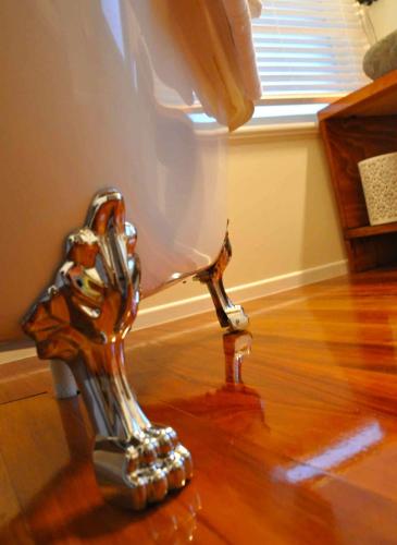 a metal dog statue sitting on a wooden floor at Hosking House in New Plymouth