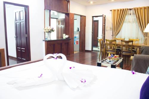 a hotel room with a bed and a dining room at Hoa Phat Hotel & Apartment in Ho Chi Minh City