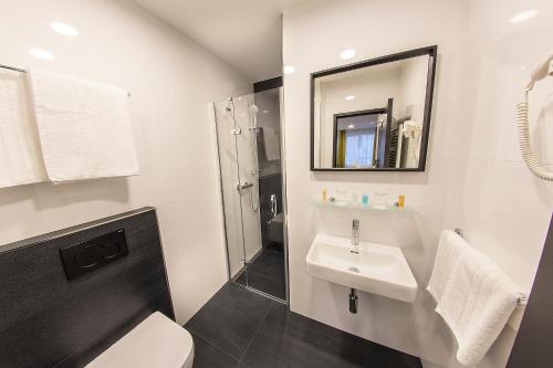 uma casa de banho com um lavatório, um WC e um espelho. em Hotel Valcha em Praga