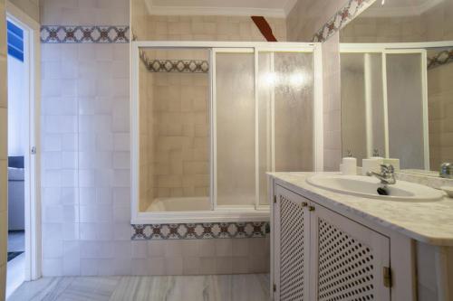 y baño con lavabo y ducha. en AlohaMundi Bailén, en Sevilla