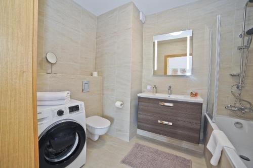 a bathroom with a washing machine and a sink at Grand Apartments - Three bedrooms with panorama of the Old Town in Gdańsk