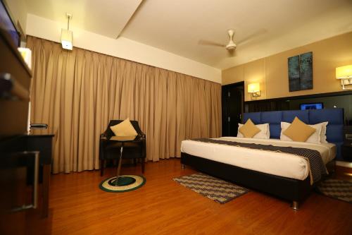 a bedroom with a bed and a chair in it at Quality Inn Bez Krishnaa in Visakhapatnam