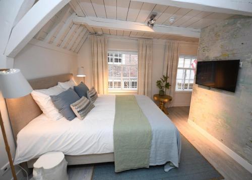 - une chambre avec un grand lit et une télévision à écran plat dans l'établissement Hotel 't Fnidsen, à Alkmaar