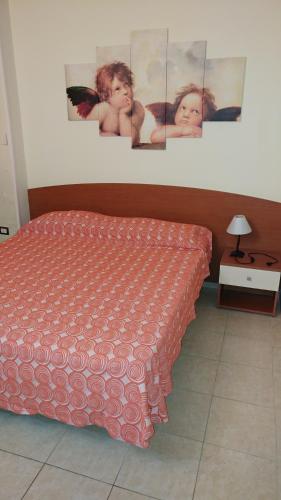a bedroom with a bed and pictures on the wall at Residence Parco del Sole in Rodi Garganico