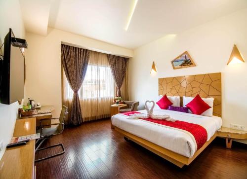 a bedroom with a large bed with red pillows at Hotel Rockdale in Visakhapatnam