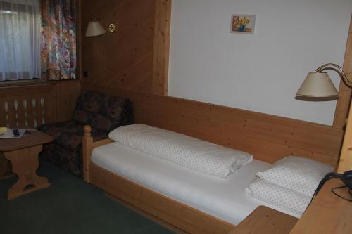 a small room with a bed and a chair at Martinshof in Obergurgl