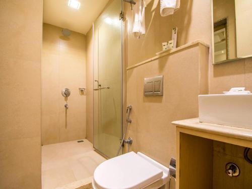 a bathroom with a shower and a toilet and a sink at Hotel Rockdale in Visakhapatnam