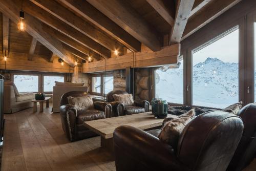 a living room with a table and chairs and a mountain at Sunny Valley Mountain Lodge in Bormio