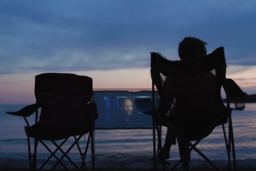 a person sitting in chairs on the beach at sunset at Apartment Castel in Bale