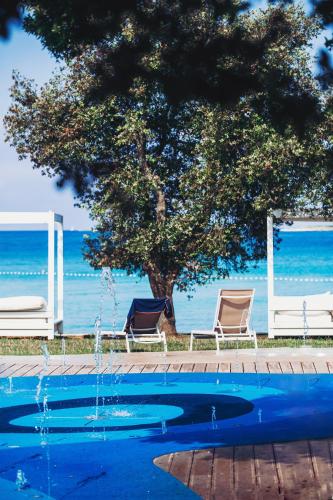 a swimming pool with two chairs and a tree at Apartment Castel in Bale