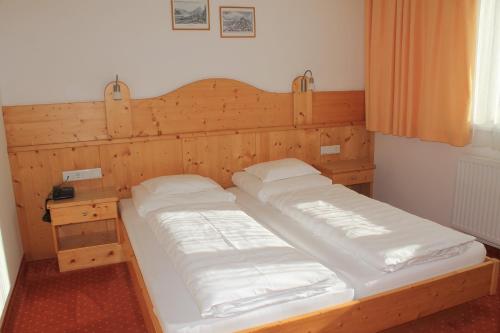 a wooden bed with two pillows on top of it at Martinshof in Obergurgl