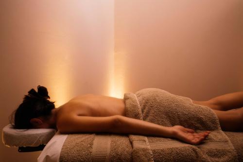 a naked woman laying on a bed with a towel at Belvedere Luxury Apartments & Spa in Plakias