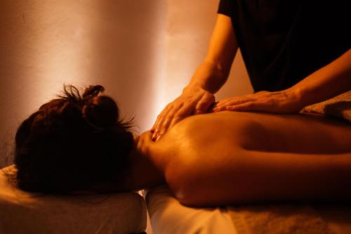 a woman getting a back massage on a bed at Belvedere Luxury Apartments & Spa in Plakias