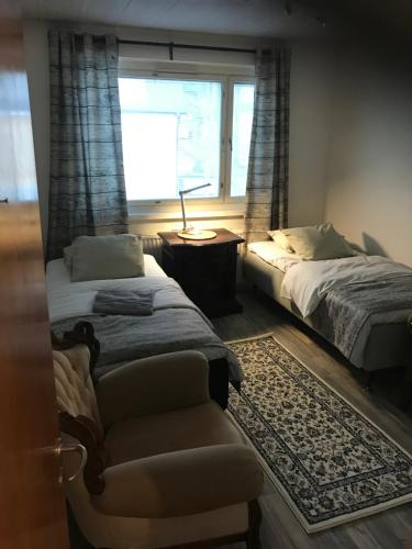 ein Schlafzimmer mit zwei Betten, einer Couch und einem Fenster in der Unterkunft Residence 4 in Tampere