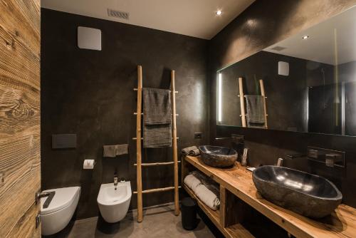 a bathroom with two sinks and two toilets at Sunny Valley Mountain Lodge in Bormio