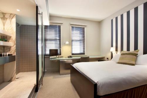 a bedroom with a bed and a desk with a computer at Lancemore Mansion Hotel Werribee Park in Werribee