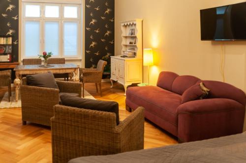 uma sala de estar com um sofá e cadeiras e uma televisão em Studio Apartment Berlin em Berlim