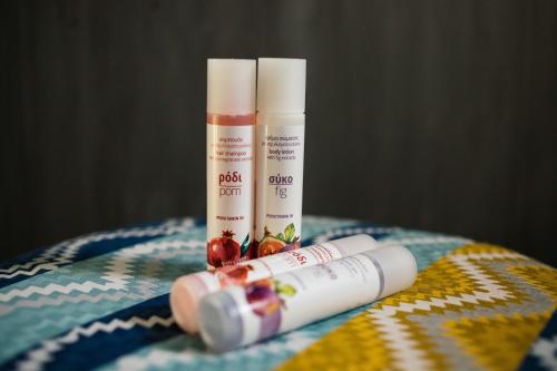 two tubes of sunscreen sitting on top of a blanket at Belvedere Luxury Apartments & Spa in Plakias