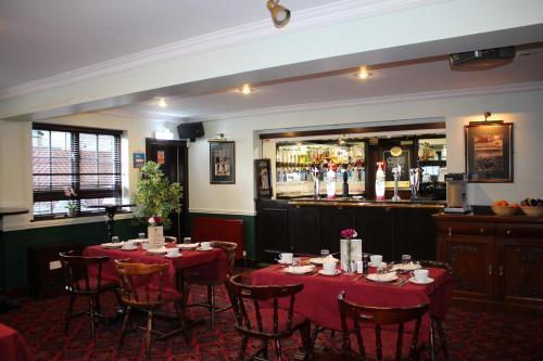 a dining room with tables and chairs and a bar at Ardmillan Hotel in Edinburgh