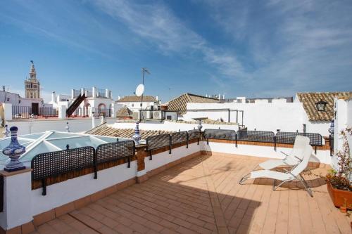 a patio with a hot tub on top of a building at Suites Machado in Seville