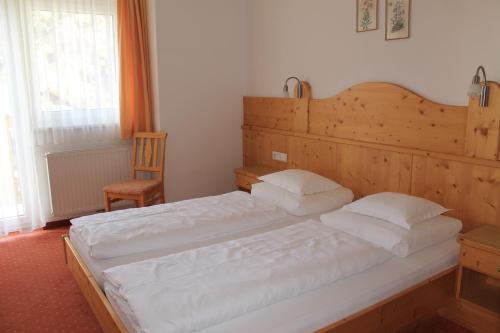 a bedroom with a large bed and a chair at Martinshof in Obergurgl