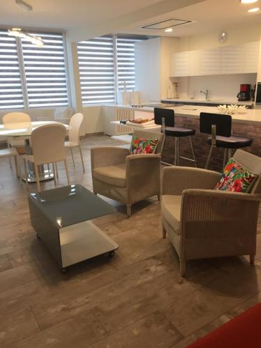 Il comprend un salon avec des chaises et des tables ainsi qu'une cuisine. dans l'établissement résidence tingitana, à Saint-Jean-de-Luz