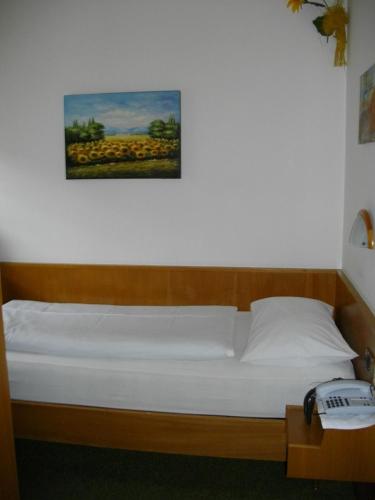 a bed in a room with a picture on the wall at Hotel Villa Emilia in Ortisei