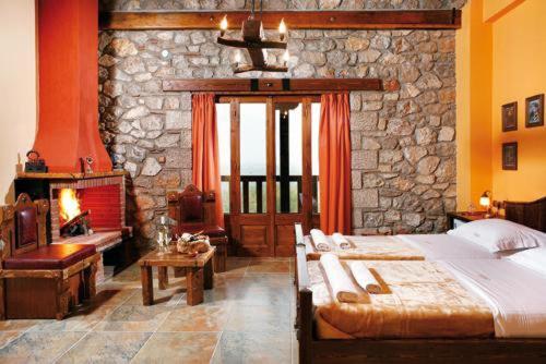 a bedroom with a large bed and a stone wall at Metohi in Marioláta