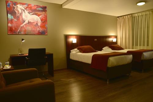 a hotel room with two beds and a painting of a horse at Hotel Manso de Velasco in San Fernando