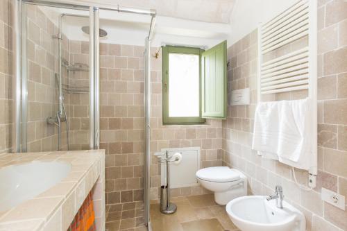 a bathroom with a toilet and a sink and a shower at Trulli Masseria Donno Santo in Ceglie Messapica