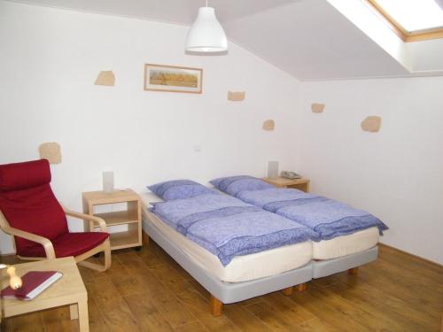 1 dormitorio con 1 cama y 1 silla roja en Maison Neuve Grandval, en Grandval