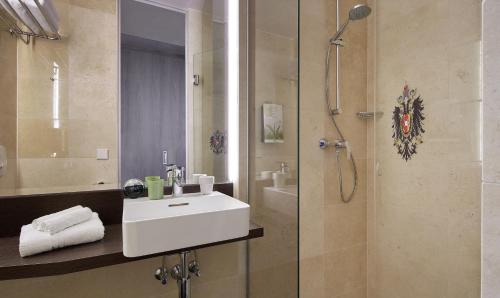 a bathroom with a sink and a shower at Living Hotel Kaiser Franz Joseph in Vienna