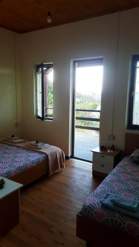a bedroom with two beds and a sliding glass door at Quiet Villa Near Berat - Scenic Balcony & Garden in Berat