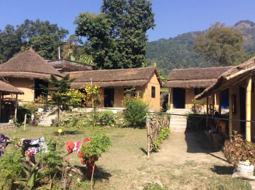 a house with thatched roofs and a yard with plants at My beautiful cottage in pokhara in Pokhara