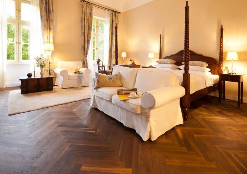 ein Wohnzimmer mit 2 Betten und einem Sofa in der Unterkunft Schlosshotel Ziethen in Kremmen