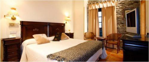 a bedroom with a large bed and a television at La Casona de Pío in Cudillero