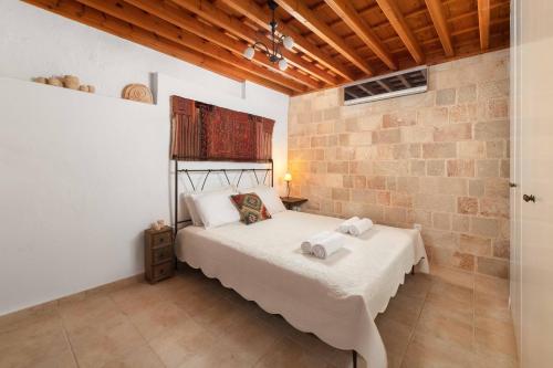 una camera da letto con un letto e un muro di mattoni di Villa Valasia Lindos with Acropolis View a Líndos
