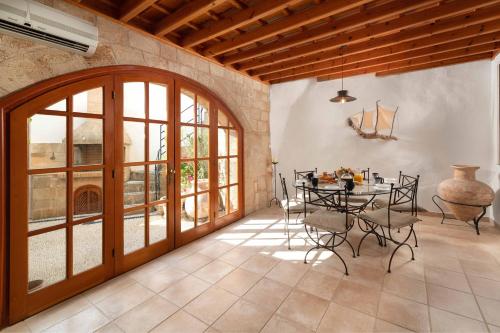 una sala da pranzo con tavolo, sedie e finestre di Villa Valasia Lindos with Acropolis View a Líndos
