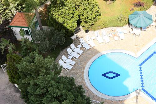 an overhead view of a swimming pool with chairs and an umbrella at Zoukotel Hotel in Jounieh