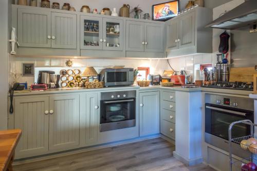 a kitchen with white cabinets and blue appliances at Peace Valley Guesthouse in Napier