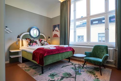 a bedroom with a bed and a chair and a mirror at The Apartments Company - The Sweet in Oslo